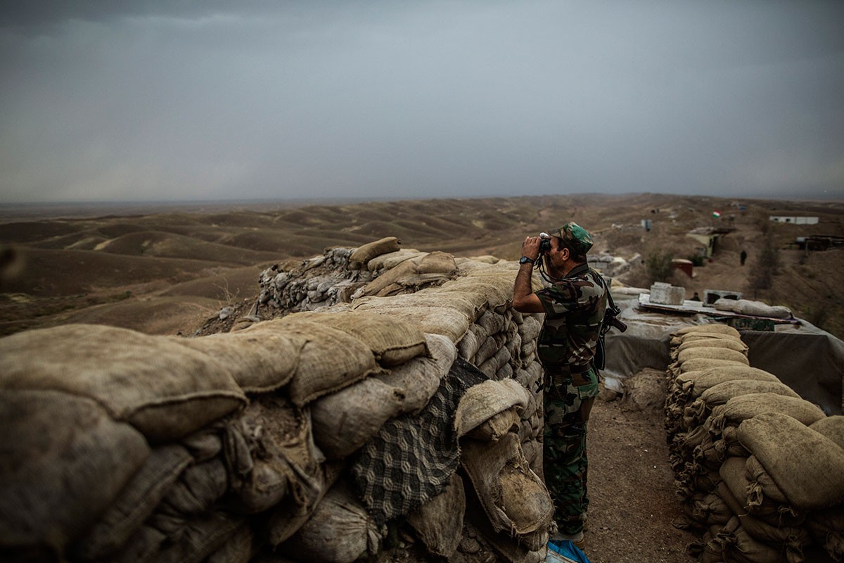 Một dân quân người Kurd dùng ống nhòm quan sát các vị trí đồn trú của IS gần Kirkuk.